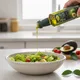 Aceite de palta virgen siendo vertido sobre ensalada fresca